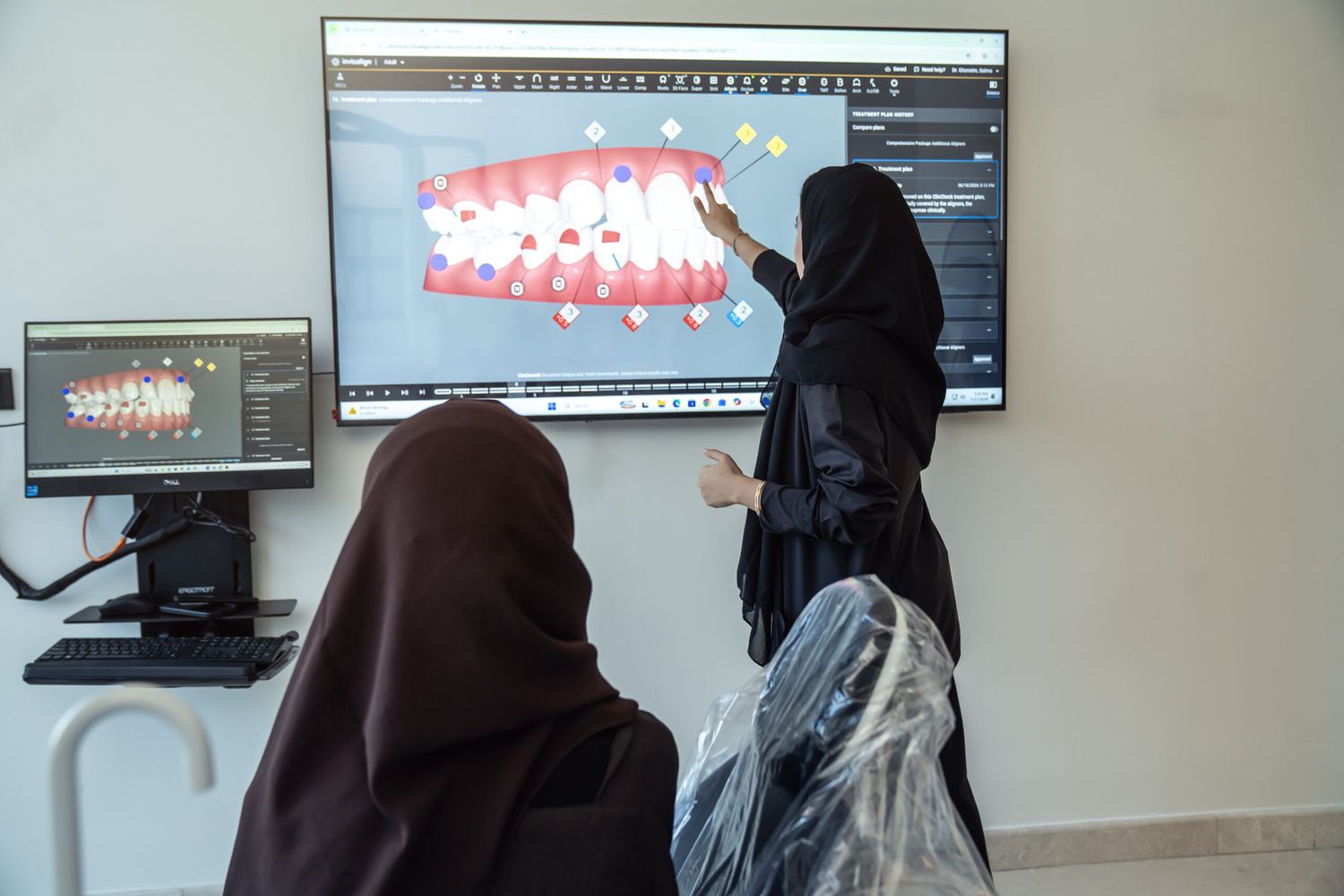 A clinician at Tam Dental in Jeddah reviewing a three-dimensional digital scan of a patient's upper and lower teeth on a large wall-mounted screen.
